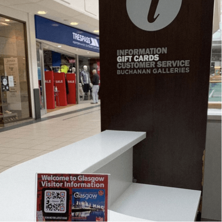 Code QR sur un cavalier de table dans un point d’informations permettant au public d’accéder aux infos de Downtown City Maps à Glasgow