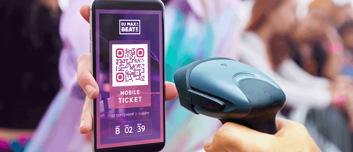 Une personne se rendant à un festival présente son billet mobile par code QR tandis que quelqu’un d’autre le scanne.