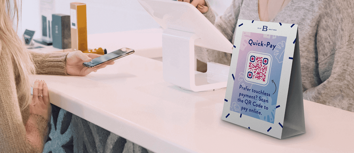 Deux femmes dans une boutique et un cavalier de table avec un code QR sur le comptoir du point de vente.