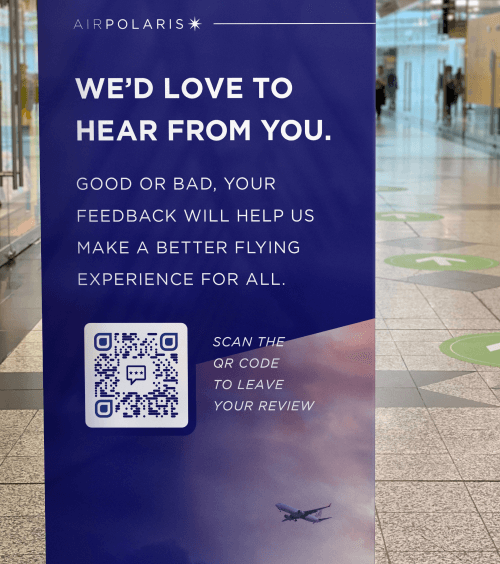 Code QR sur la bannière d’une compagnie aérienne encourageant la clientèle à donner son avis sur les vols.