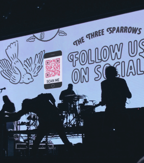 Affichage sur scène en concert d’un code QR vers les médias sociaux du groupe.