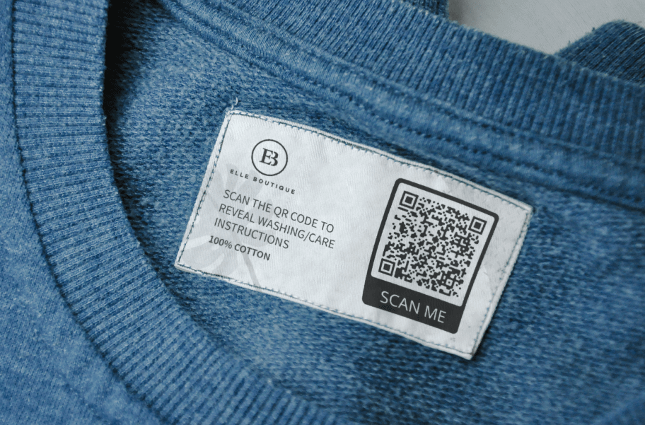 Étiquette sur le col d’un pull bleu avec code-barres 2D comprenant les instructions de lavage et d’entretien de l’article.